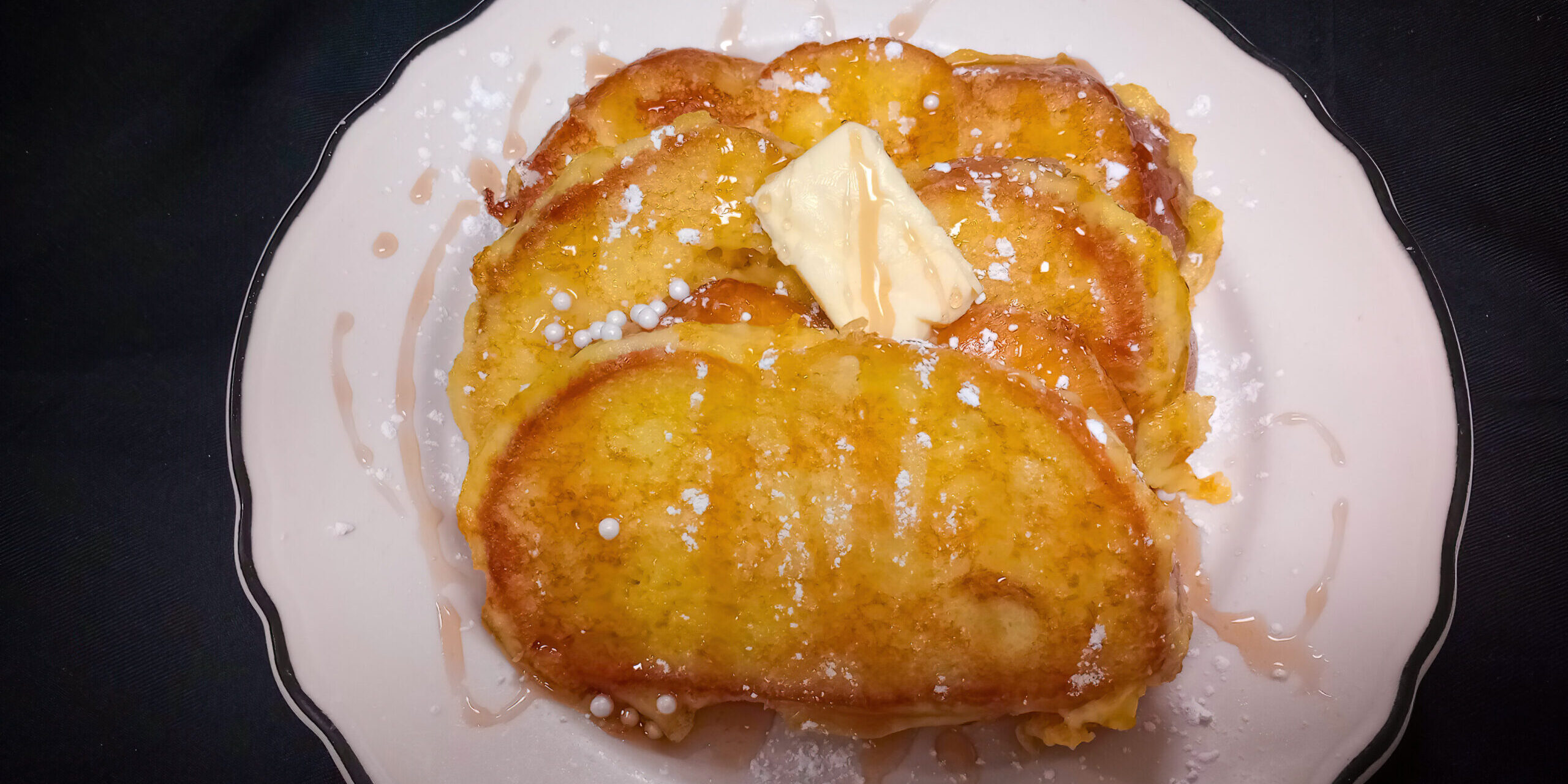 challah french toast with syrup & a pat of butter on top